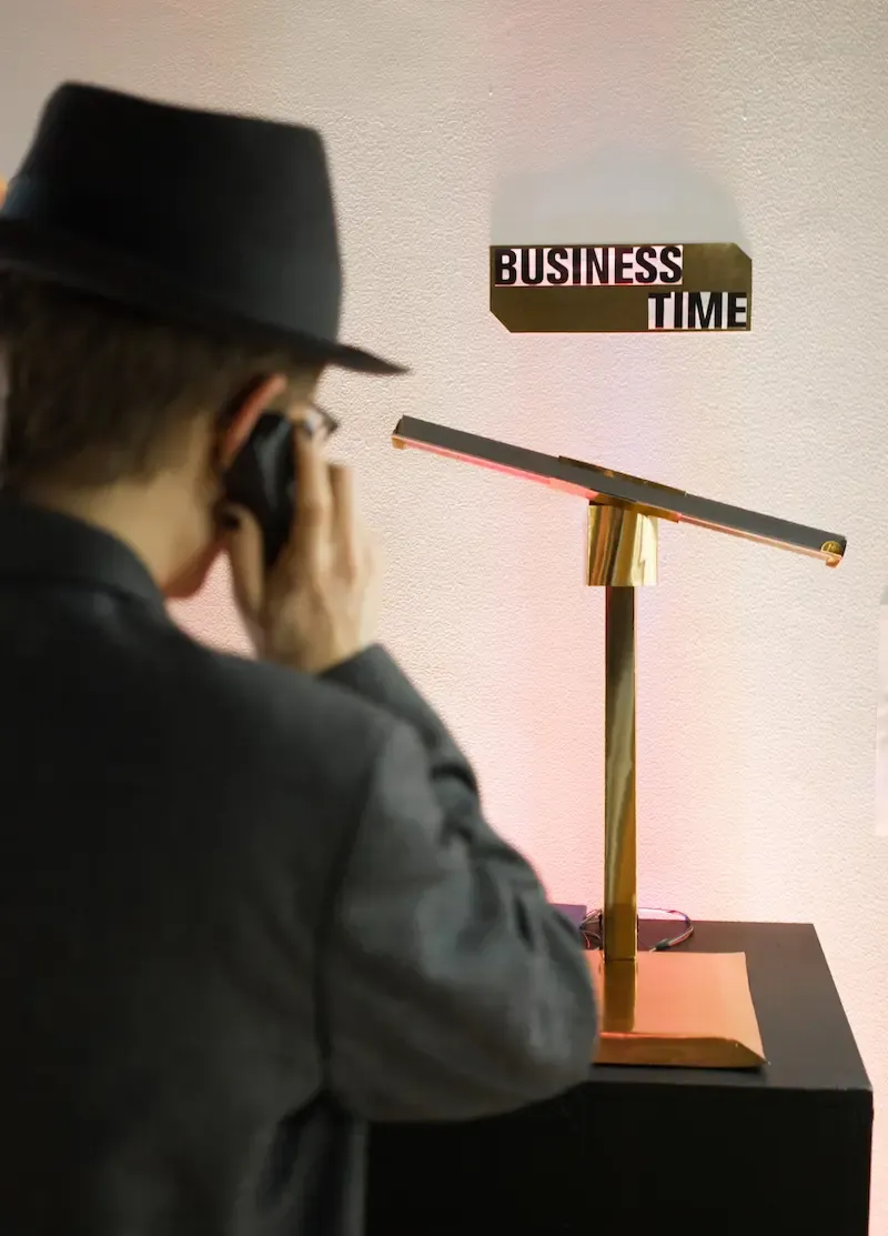 A person dressed in formal clothes speaking on the phone looking at a scales.