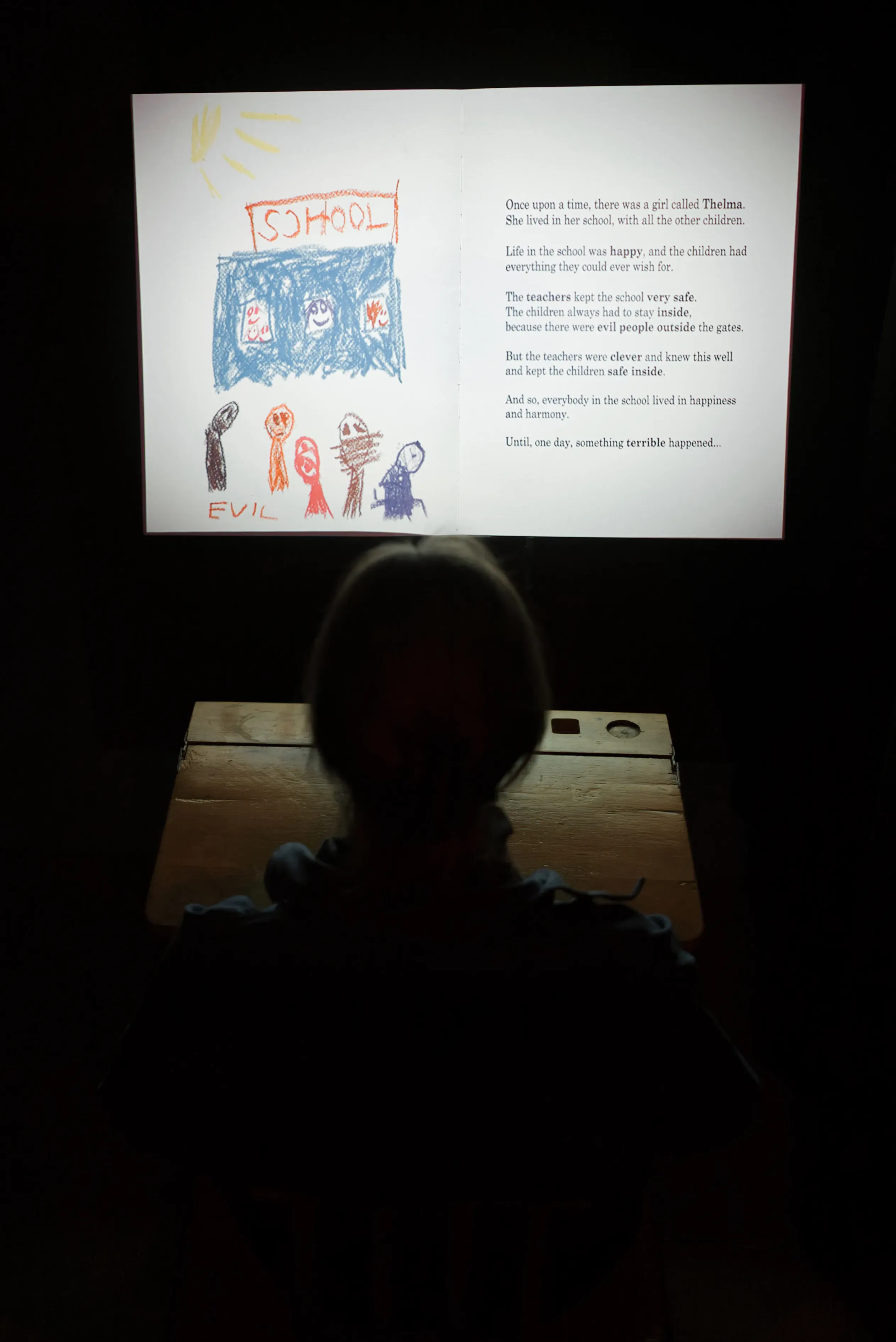 A person staring at a book with a colorful illustration and text.