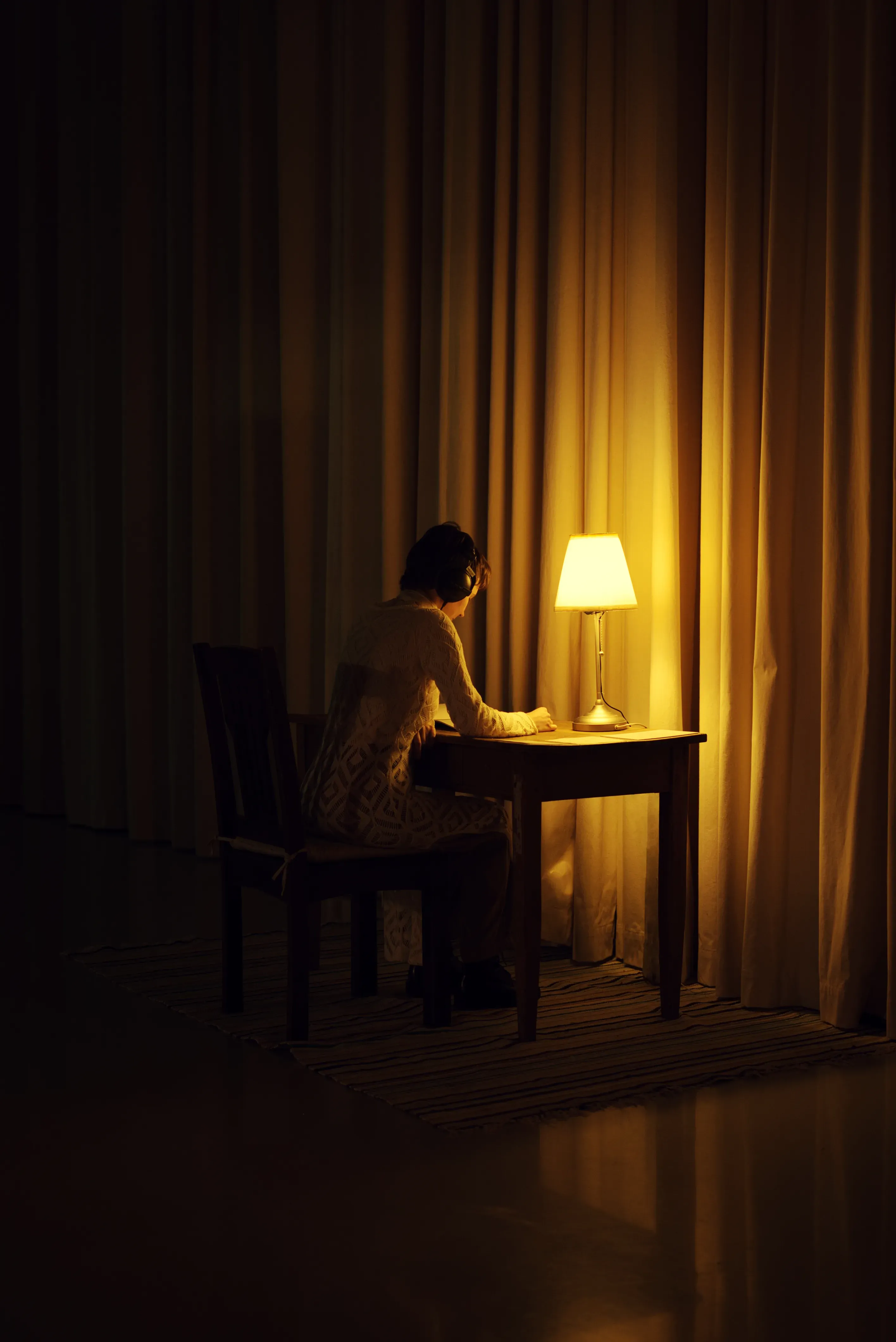 A person wearing headphones reading a book.